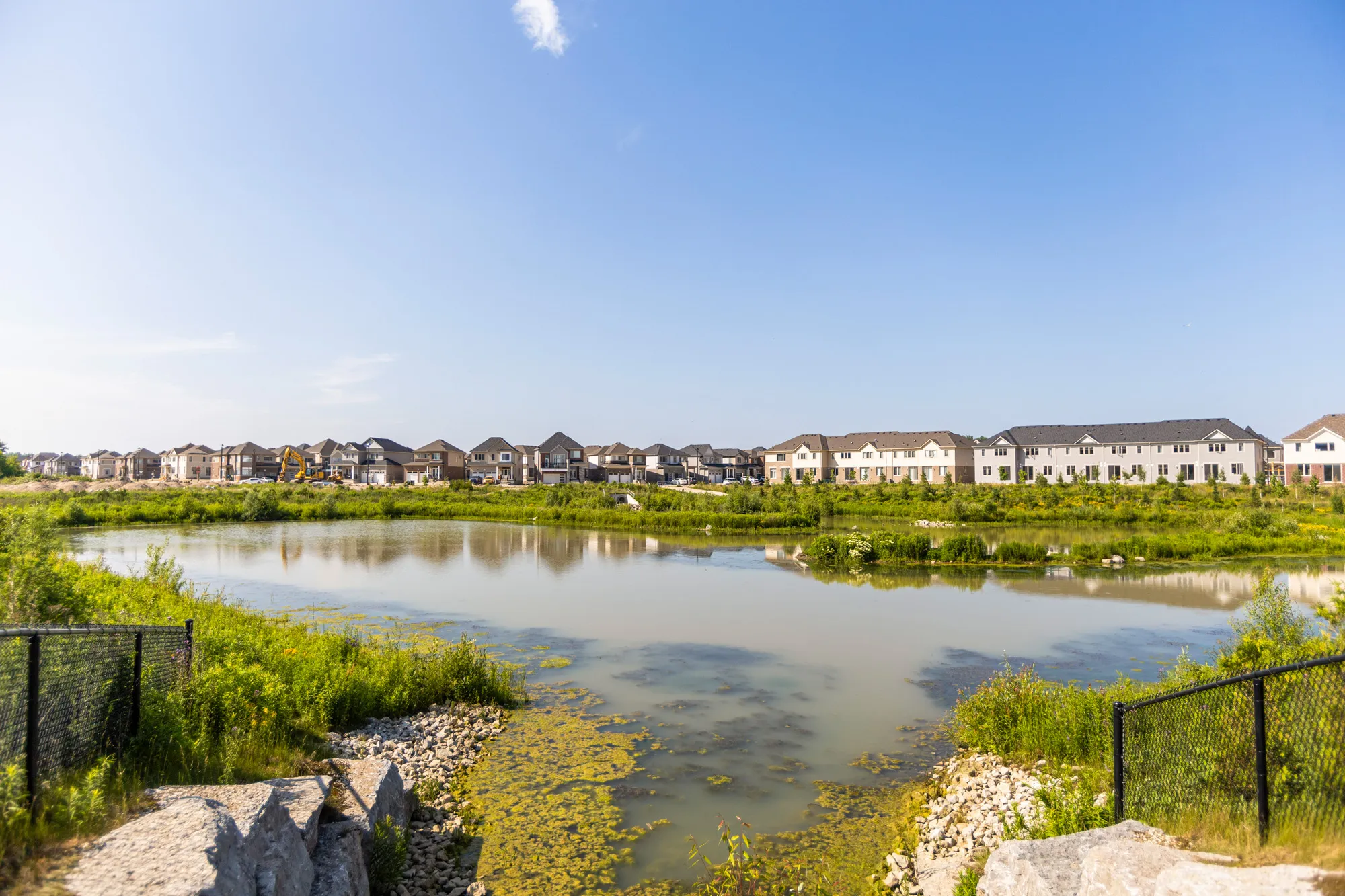 Sorbara Nigus Development - Drainage pond with subdivision in background